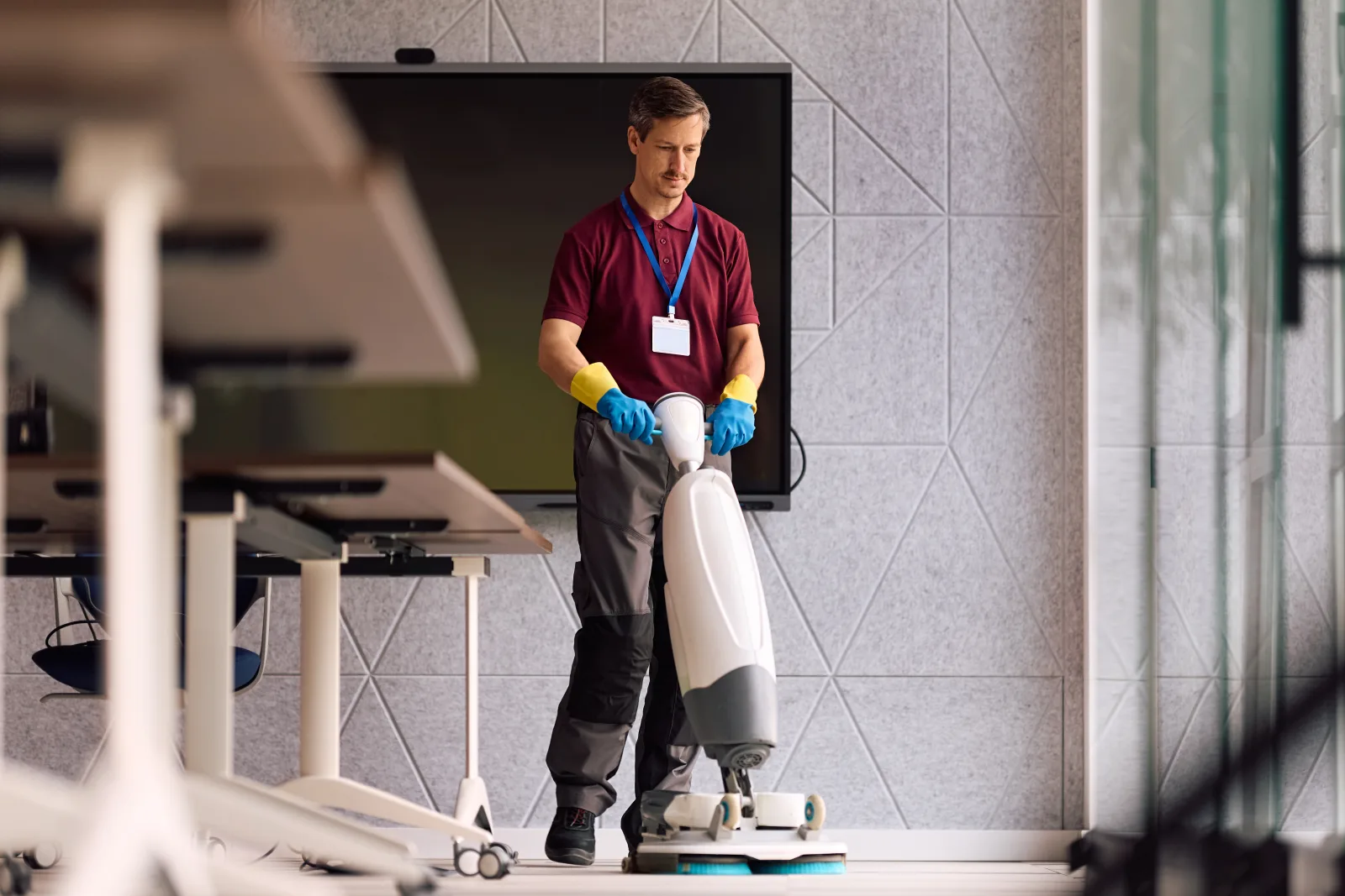 Gebäudereiniger pflegt den Büroboden mit professioneller Maschine
